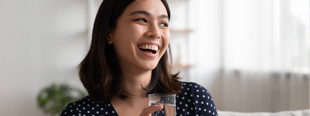 ragazza che tiene in mano un bicchiere d'acqua